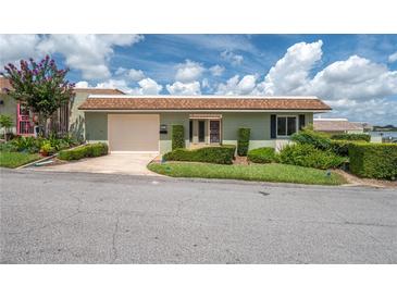 Charming single-story home with a light green exterior, well-manicured lawn and attached garage at 2219 Starboard Rd, Winter Haven, FL 33881