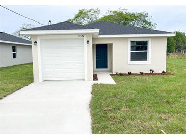 Charming single-story home with a well-manicured lawn, a driveway, and a blue front door at 2521 Sunset Dr, Winter Haven, FL 33881