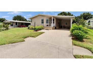 Charming single-story home with a well-maintained lawn and a convenient carport at 451 Village Sw Cir, Winter Haven, FL 33880