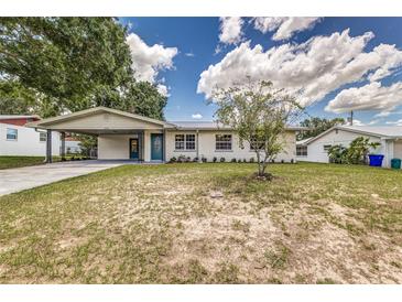 Charming single-story home with white exterior, carport, landscaped yard and inviting blue front door at 508 Boger N Blvd, Lakeland, FL 33803