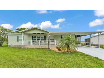 Charming single-story home with a well-manicured lawn and carport at 6509 Oak Hammock Ct, Winter Haven, FL 33884