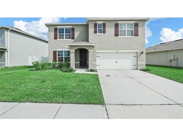 Charming two-story home featuring a well-manicured lawn and a two-car garage at 2811 Grandbury Grove, Lakeland, FL 33811
