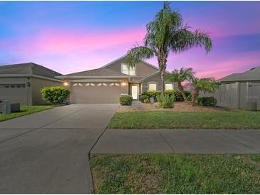 Charming home featuring a two-car garage and a well-manicured lawn with beautiful landscaping at 5611 Aral Dr, Lakeland, FL 33805
