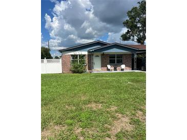 Charming single-story home with brick accents, covered carport, and well-maintained front lawn at 5907 Sharon Ln, Lakeland, FL 33809