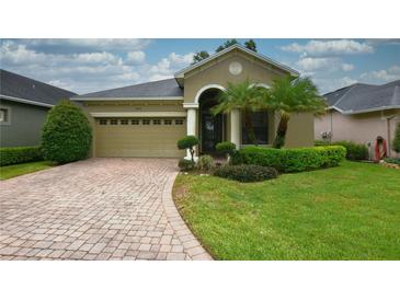 Charming single-story home featuring a well-manicured lawn, brick driveway, and an attached two-car garage at 6408 Christina Chase Pl, Lakeland, FL 33813