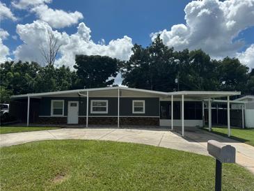 Charming one-story home featuring a well-manicured lawn, covered parking, and classic architectural details at 508 Garden N Dr, Lakeland, FL 33813