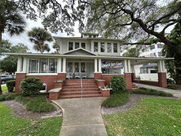 Two-story house with brick facade, large porch, and mature landscaping at 214 S Riverside Dr, New Smyrna Beach, FL 32168