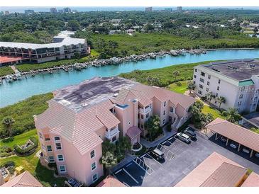 Aerial view of waterfront condo building with parking and boat slips at 434 Bouchelle Dr # 304, New Smyrna Beach, FL 32169