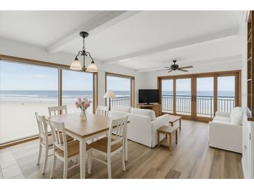Bright living room with ocean views, modern furnishings, and hardwood floors at 4811 Saxon Dr # C102, New Smyrna Beach, FL 32169