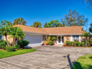 Brick house with a brown roof, white garage door, and well-maintained landscaping at 103 Sea St, New Smyrna Beach, FL 32168