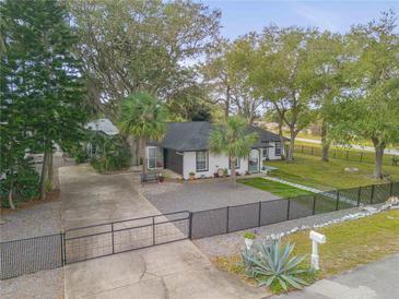 Single-story home with a fenced yard and long driveway at 2304 Date Palm Dr, Edgewater, FL 32141