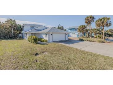 White two-story house with attached garage and grassy yard at 239 Kirkland Rd, New Smyrna Beach, FL 32169