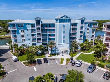 Aerial view of waterfront condo building with parking and landscaping at 3 Riverwalk Dr # 401, New Smyrna Beach, FL 32169