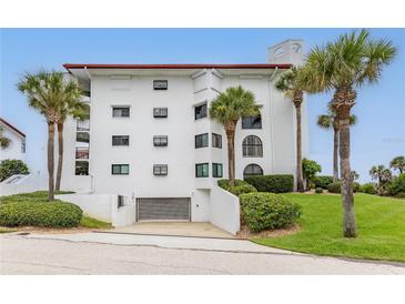 White building exterior with palm trees and a garage at 3001 S Atlantic Ave # 503, New Smyrna Beach, FL 32169