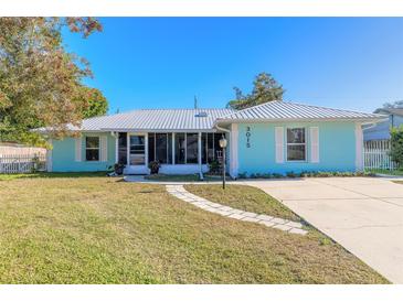 Light teal house with metal roof, walkway, and well-maintained lawn at 3015 Queen Palm Dr, Edgewater, FL 32141