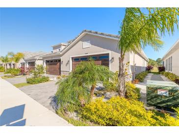 Tan two-story home with dark brown garage doors and landscaping at 3042 Isles Way, New Smyrna Beach, FL 32168