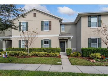 Tan two-story house with green shutters and landscaping at 4825 Apple Blossom Ln, Saint Cloud, FL 34771