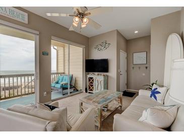 Bright living room with ocean view, comfy seating, and coastal decor at 6612 S Atlantic Ave # 201, New Smyrna Beach, FL 32169