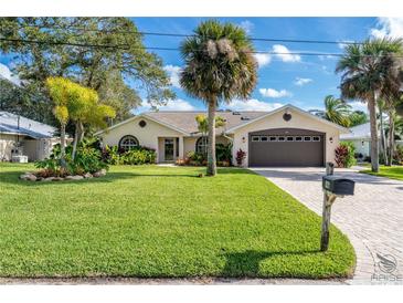 Single-story home with landscaped yard and attached garage at 831 Evergreen St, New Smyrna Beach, FL 32169