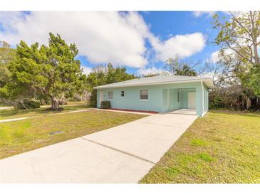 Light blue house with a driveway and grassy yard at 1210 Washington St, New Smyrna Beach, FL 32168