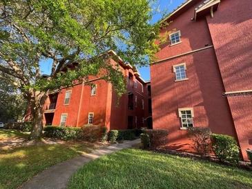 Exterior view of a red brick condo building with landscaping at 132 Vista Verdi Cir # 100, Lake Mary, FL 32746