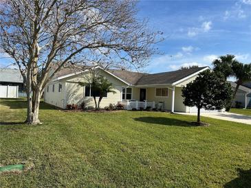 One-story house with light yellow siding, and a well-maintained lawn at 216 Fairgreen Ave, New Smyrna Beach, FL 32168