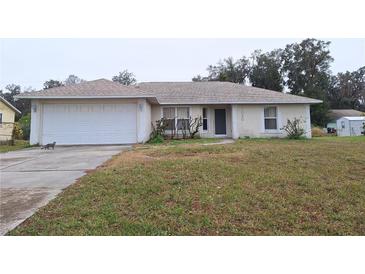 Single-story house with attached garage and grassy yard at 3020 Kumquat Dr, Edgewater, FL 32141