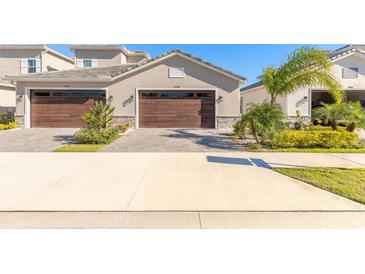 Two-car garage, light brown doors, landscaping, and a paved driveway at 3069 Isles Way, New Smyrna Beach, FL 32168