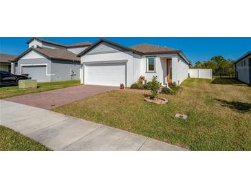 Charming single-Gathering home featuring a brick driveway, green lawn, and white exterior at 3191 Crab Trap Dr, New Smyrna Beach, FL 32168