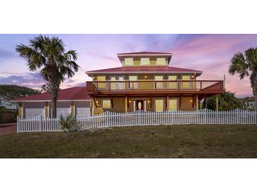 Two-story house with red metal roof, white fence, and palm trees at 3726 S Atlantic Ave, New Smyrna Beach, FL 32169