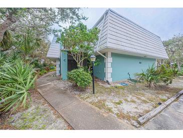 Exterior view of condo unit with walkway and landscaping at 4150 S Atlantic Ave # 112C, New Smyrna Beach, FL 32169