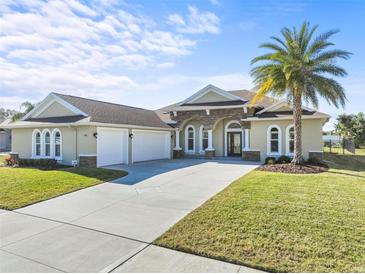 Beautiful tan house with three-car garage and palm tree at 508 Campana St, New Smyrna Beach, FL 32168