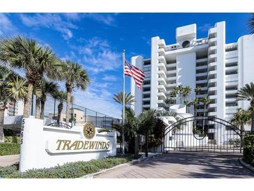 Tradewinds building, featuring a gated entrance and palm trees at 5255 S Atlantic Ave # 1103, New Smyrna Beach, FL 32169