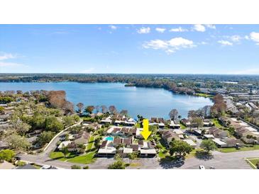 Aerial view of lakeside villas with meticulously maintained lawns under a partly cloudy blue sky at 632 Sausalito Blvd, Casselberry, FL 32707