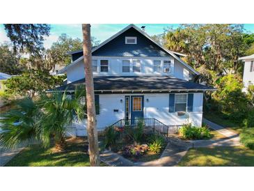 Charming two-story home with blue accents and mature landscaping at 1116 Magnolia St, New Smyrna Beach, FL 32168