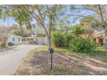 Charming light green house with a spacious front yard and mature trees at 1506 Palmetto St, New Smyrna Beach, FL 32168