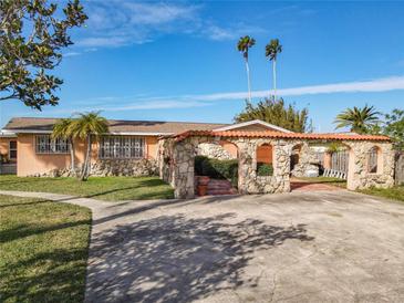 Single-story home with stone accents and a covered patio at 2 Richmond Dr, New Smyrna Beach, FL 32169