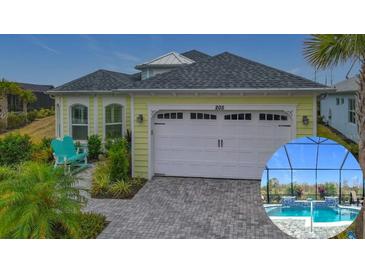 House exterior featuring a two-car garage and a captivating pool and patio area at 205 Blue Starfish Pl, Daytona Beach, FL 32124