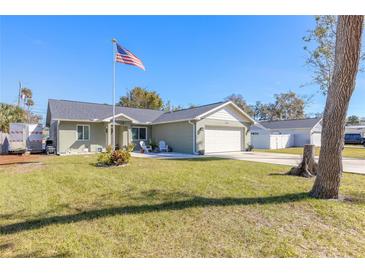 Newly constructed home with a landscaped lawn and attached garage at 2717 Needle Palm Dr, Edgewater, FL 32141