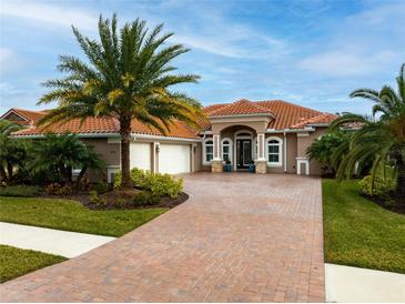 Elegant single-story home boasting a three-car garage, brick-paved driveway, and mature landscaping at 2824 S Asciano Ct, New Smyrna Beach, FL 32168