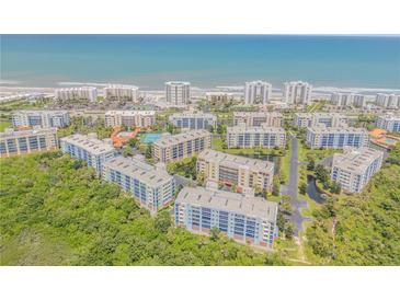 Stunning aerial view of beachfront condos, lush greenery, and ocean views at 5300 S Atlantic Ave # 5-206, New Smyrna Beach, FL 32169