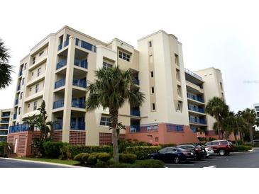 Tan building with blue accents and palm trees, offering multiple levels and parking at 5300 S Atlantic Ave # 8-302, New Smyrna Beach, FL 32169