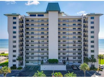 Oceanfront building, multiple floors, balconies, and parking at 5499 S Atlantic Ave # 904, New Smyrna Beach, FL 32169