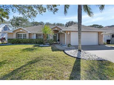 Brick house with a well-maintained lawn and palm trees at 809 E 7Th Ave, New Smyrna Beach, FL 32169