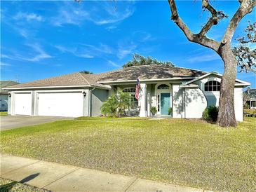 Charming single-story home features a three-car garage and a well-maintained lawn under a bright blue sky at 107 Old Sunbeam Dr, South Daytona, FL 32119