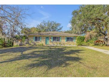 Cute ranch home with green shutters and a well-manicured lawn at 1732 Travelers Palm Dr, Edgewater, FL 32132