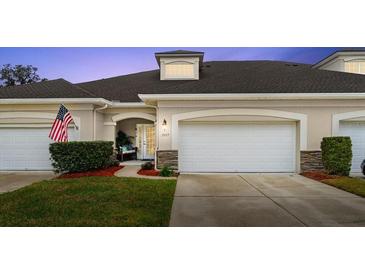 Inviting exterior of two-story townhome with attached garage and landscaped lawn at 1957 Turnbull Lakes Dr, New Smyrna Beach, FL 32168