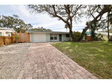 Light green house with brick driveway, and mature trees in the front yard at 2307 Saxon Dr, New Smyrna Beach, FL 32169