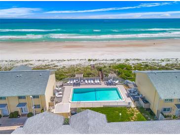 Breathtaking aerial view showcasing a beachside complex with a sparkling pool and direct beach access at 4773 S Atlantic Ave # 10, Ponce Inlet, FL 32127