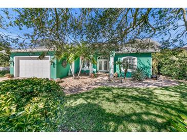 Charming teal home with landscaped yard and attached garage at 50 Pompano Dr, Ponce Inlet, FL 32127